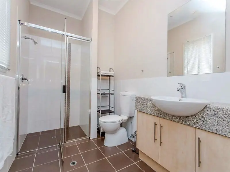A bathroom at the Condamine Street home, with a glass shower and vanity