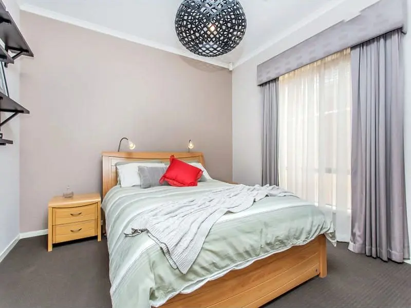 A bedroom at the Condamine Street home, with a double bed and full-length curtains