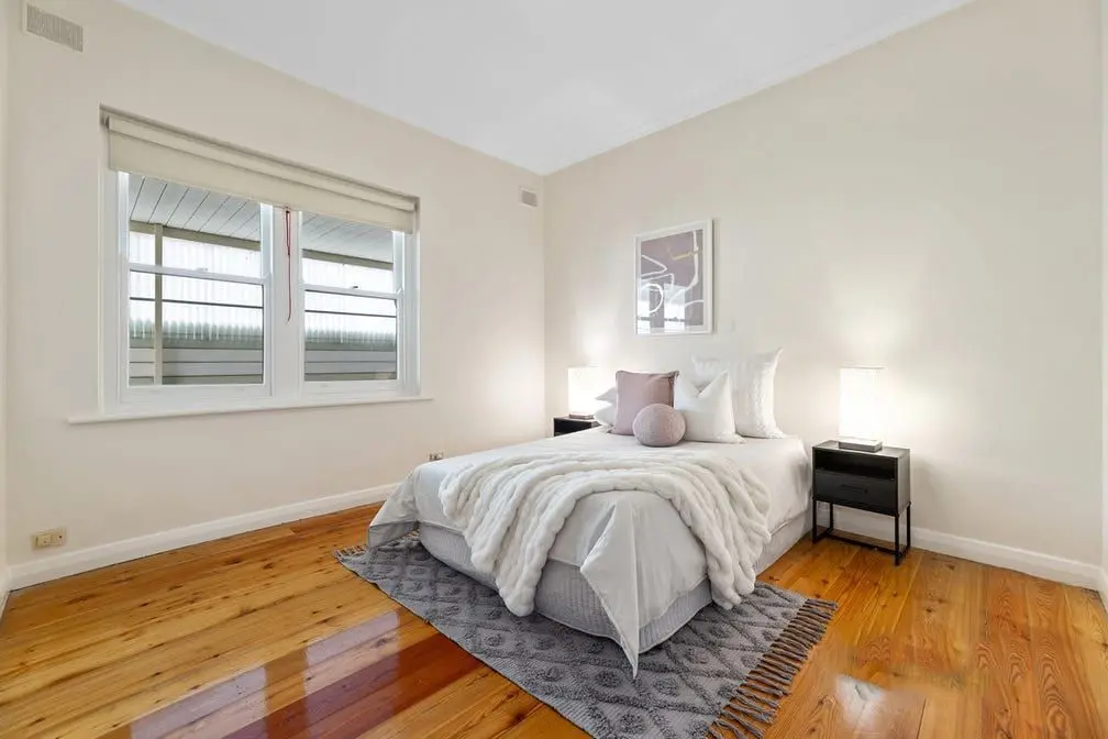 A bedroom at the Colton Avenue home, with timber floors and a double bed