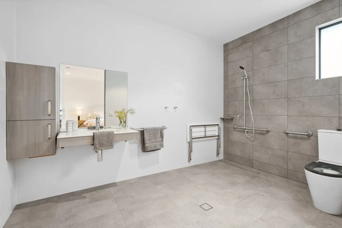The bathroom at the Wyndham Road home, with a level-entry shower, grab rails and a fold-down seat